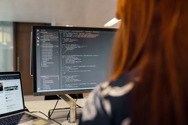 Female software engineer codes at computer